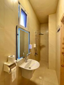 y baño con lavabo y espejo. en Jabal Dana Hotel - the highest hotel in Jordan, en Dana