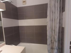 a bathroom with a brown and white shower curtain at Studio Villard-de-Lans, 1 pièce, 4 personnes - FR-1-515-68 in Villard-de-Lans