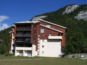 a large building in front of a mountain at Studio Corrençon-en-Vercors, 1 pièce, 4 personnes - FR-1-515-67 in Corrençon-en-Vercors