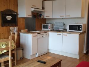 a kitchen with white cabinets and white appliances at Charmant 2 Pièces en Cœur de Village, Proche Piscine et Patinoire - 5 Pers, 46m² - FR-1-515-89 in Villard-de-Lans