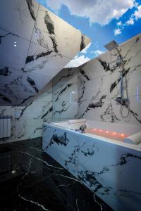 baño con pared de mármol blanco y negro en Villa Balos, en Gronków