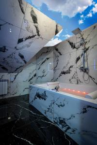 a bathroom with a black and white marble wall at Villa Balos in Gronków