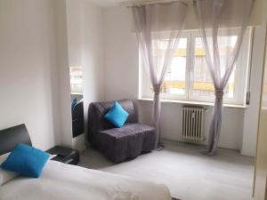 a bedroom with a bed and a chair and a window at J&M HOUSE -Fronte Ospedale- in Udine