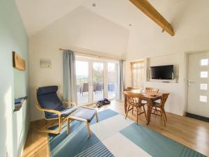a living room with a table and chairs and a television at Skyber Barn, a rural retreat on Bodmin Moor in Liskeard