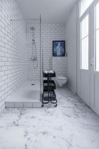 a white bathroom with a shower and a tub and a sink at Résidence Epinat II - Appartements centre - Parking in Vichy
