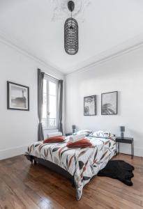 a white bedroom with a bed and a pendant light at Résidence Epinat II - Appartements centre - Parking in Vichy +28 photos