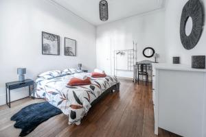 a bedroom with white walls and a bed with red pillows at Résidence Epinat II - Appartements centre - Parking in Vichy