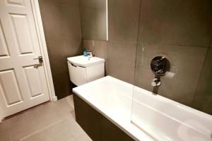 łazienka z wanną, toaletą i umywalką w obiekcie Aldgate Flats in E1. w Londynie