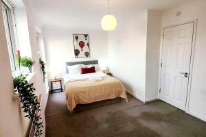 sypialnia z łóżkiem w białym pokoju w obiekcie Aldgate Flats in E1. w Londynie