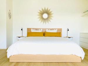 a bedroom with a large white bed with yellow pillows at Casa Vitus in Lugano
