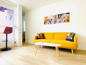 a living room with a yellow couch and a table at Casa Vitus in Lugano