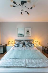 a bedroom with a large bed with two lamps at Das Schlafgut Dessau in Dessau