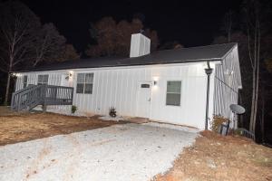 a white building with a porch at night at Dawsonville Retreat in Dawsonville