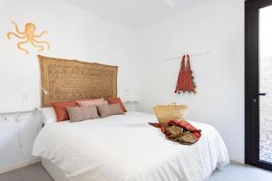 a bedroom with a white bed with a christmas tree on the wall at Home2Book Design & Breathtaking Sea Views El Porís in Poris de Abona