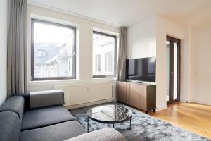 een woonkamer met een bank en een tv bij Stylish 2BR w Private Balcony in CPH City Centre in Kopenhagen