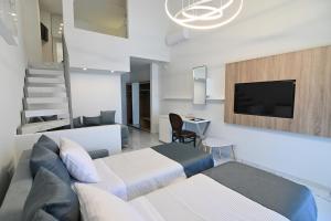 ein Schlafzimmer mit einem Bett, einem TV und einer Treppe in der Unterkunft Rihios Hotel in Stavros