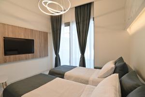 ein Hotelzimmer mit 2 Betten und einem TV in der Unterkunft Rihios Hotel in Stavros