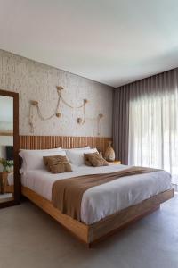 um quarto com uma cama grande e uma cabeceira em madeira em POUSADA ZAYA em São Miguel dos Milagres