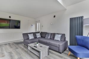 a living room with a couch and a table at Large, Modern Apartment with En-suites, Wifi, Parking by Ark SA in Sheffield
