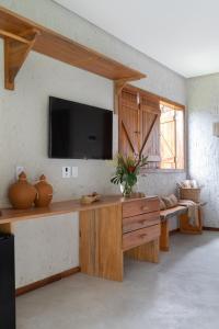 a living room with a television on a wall at POUSADA ZAYA in São Miguel dos Milagres +36 photos