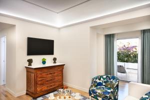 a living room with a tv and a chair at Pazziella Garden & Suites in Capri