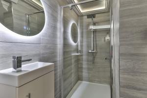 a bathroom with a shower and a sink and a mirror at Large, Modern Apartment with En-suites, Wifi, Parking by Ark SA in Sheffield