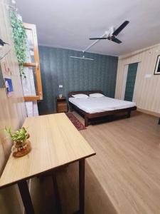 een kamer met een bed en twee tafels erin bij Green Diamond Homestay in Dehradun