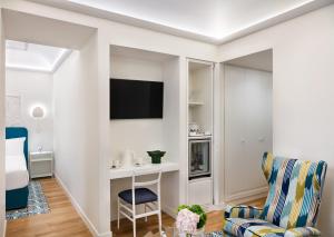 a living room with a tv and a chair at Pazziella Garden & Suites in Capri