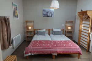 1 dormitorio con 2 camas y manta roja en Coeur de Boeur, en Houffalize