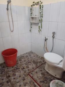 a bathroom with a toilet and a bucket at FRANGKY HOMESTAY in Manado