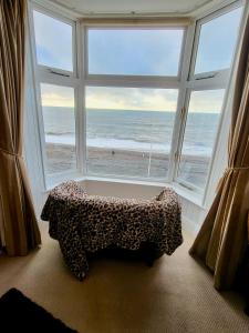 a room with a large window with a view of the ocean at Stunning Aberystwyth South Beach Apartment in Aberystwyth