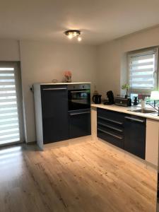 a kitchen with black appliances and a wooden floor at Sulzberg in Lahr +12 photos