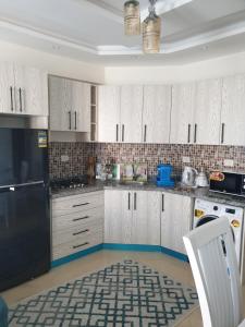 Sharm Hills في شرم الشيخ: مطبخ فيه دواليب بيضاء وثلاجة سوداء