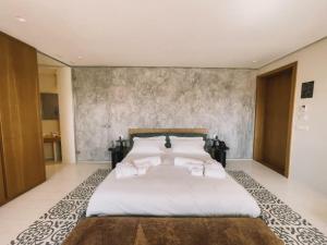 um quarto com uma cama grande com lençóis brancos e almofadas em Ognissanti Restaurant Spa Hotel Rooftop em Trani