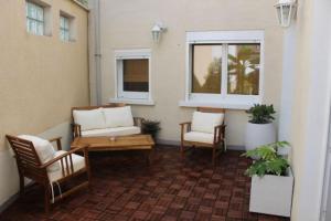 a porch with two chairs and a table and two windows at L'instant Bornéo Superbe appartement avec jacuzzi in Liancourt