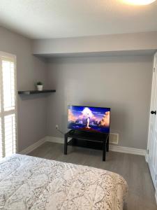 a bedroom with a flat screen tv on a wall at Beautiful Vacation Home near Toronto Airport in Mississauga