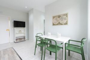 a dining room with a white table and green chairs at Urbantec Realty - Plaza de Castilla in Madrid
