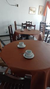 two tables and chairs with cups and saucers on them at HOTEL FERMOZA in Formosa