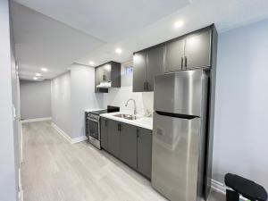 a kitchen with a stainless steel refrigerator and a sink at Beautiful Vacation Home near Toronto Airport in Mississauga