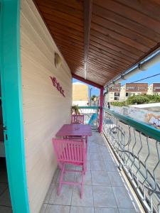 d'une table et de chaises violettes sur un balcon. dans l'établissement Hotel De la Plage, à Saint-Gilles les Bains