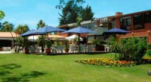 a building with umbrellas in a yard with a lawn sidx sidx at Rincon del Este in Punta del Este