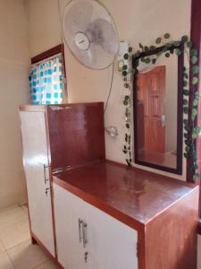 a bathroom with a refrigerator and a mirror and a fan at FRANGKY HOMESTAY in Manado