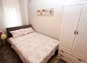 um pequeno quarto com uma cama e um armário em Apartment Ruvarceva em Belgrado