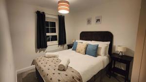 a bedroom with a bed with pillows and a window at Saxon Corner in Emsworth