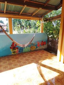 eine Veranda mit einer Hängematte auf einer Terrasse in der Unterkunft FRANGKY HOMESTAY in Manado