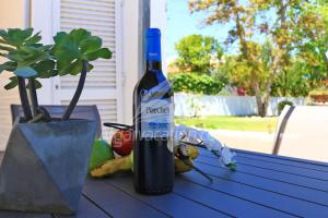 a bottle of wine sitting on a table with fruit at Villa Felicity in Porches