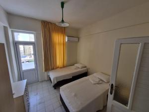 a room with two beds and a window and a mirror at Orange Grove Apart Hotel in Alanya