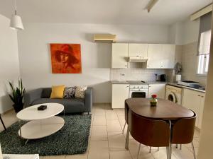 a living room with a couch and a table at Cosy one bedroom apartment in Pafos in Paphos City