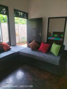 una stanza con una panca con cuscini colorati di Ruk Tree, Midigama, Weligama a Midigama East