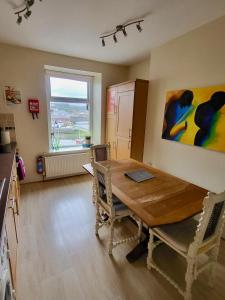 a dining room with a wooden table and a window at Stunning Aberystwyth South Beach Apartment in Aberystwyth